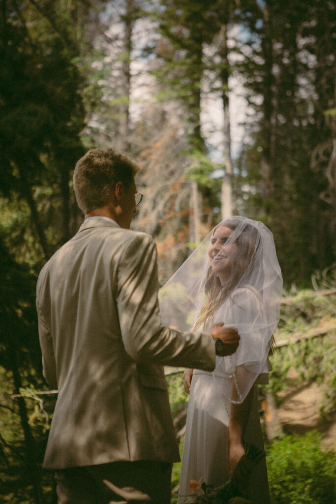 groom pulls back brides veil and gives her a kiss