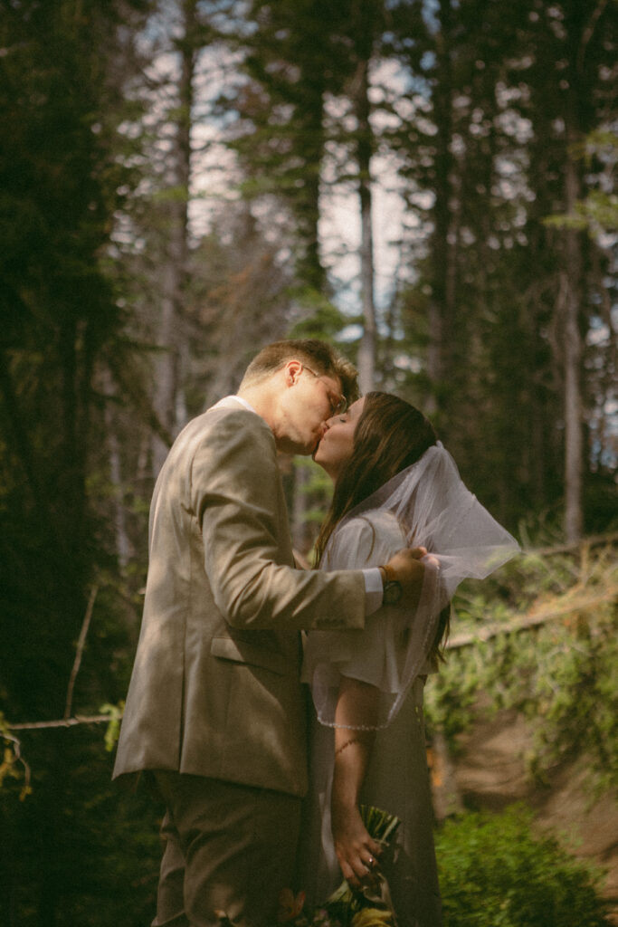 groom pulls back brides veil and gives her a kiss