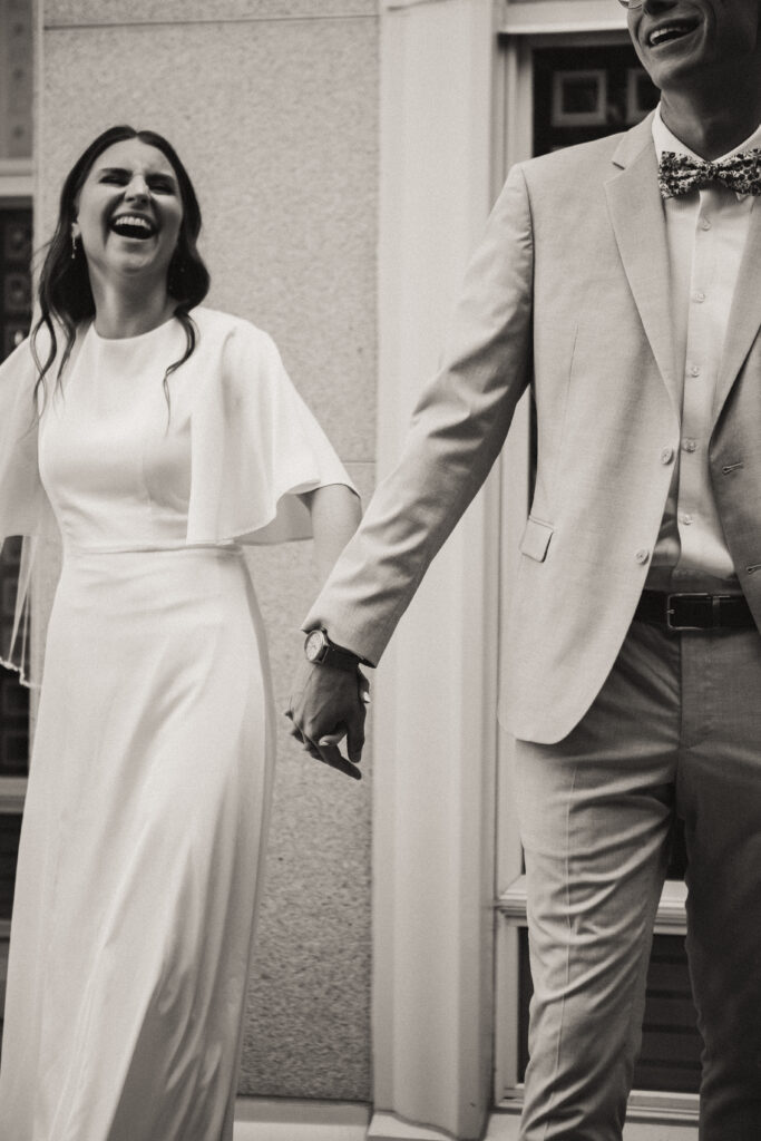 black and white detail shot of bride and groom walking hand in hand