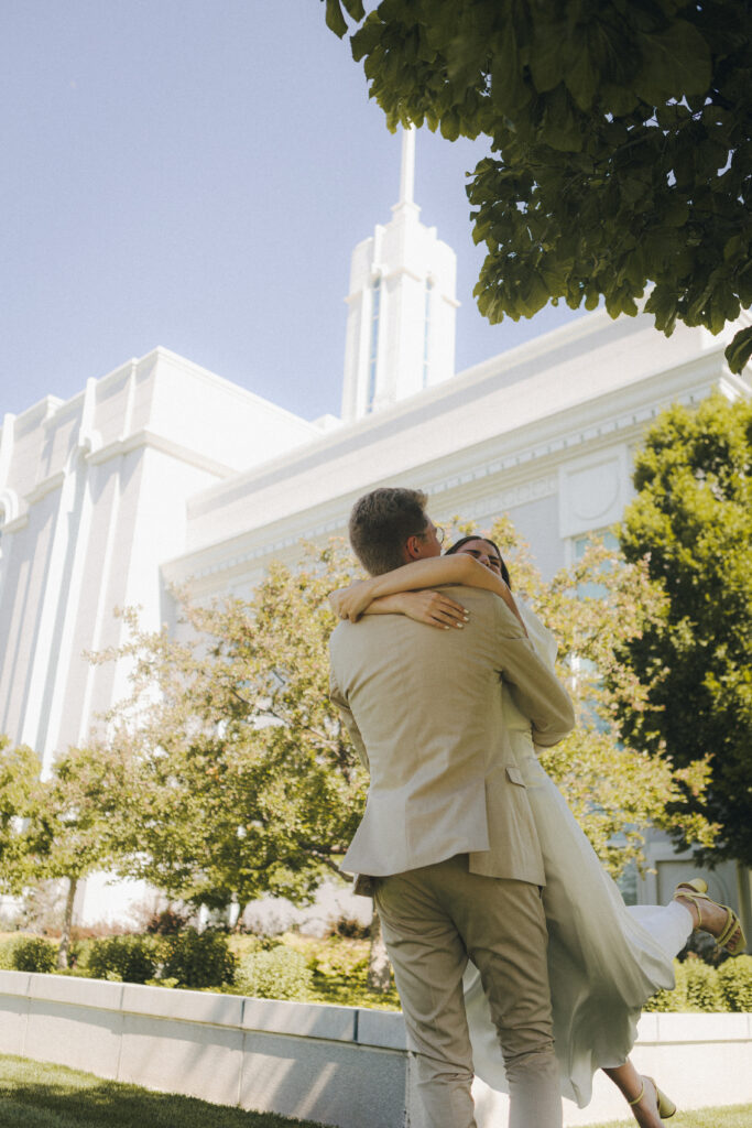 bride and groom hug by temple under tree