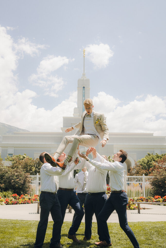 groomsmen throwing the groom in the air