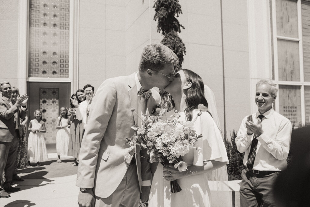 bride and groom kiss after temple exit
