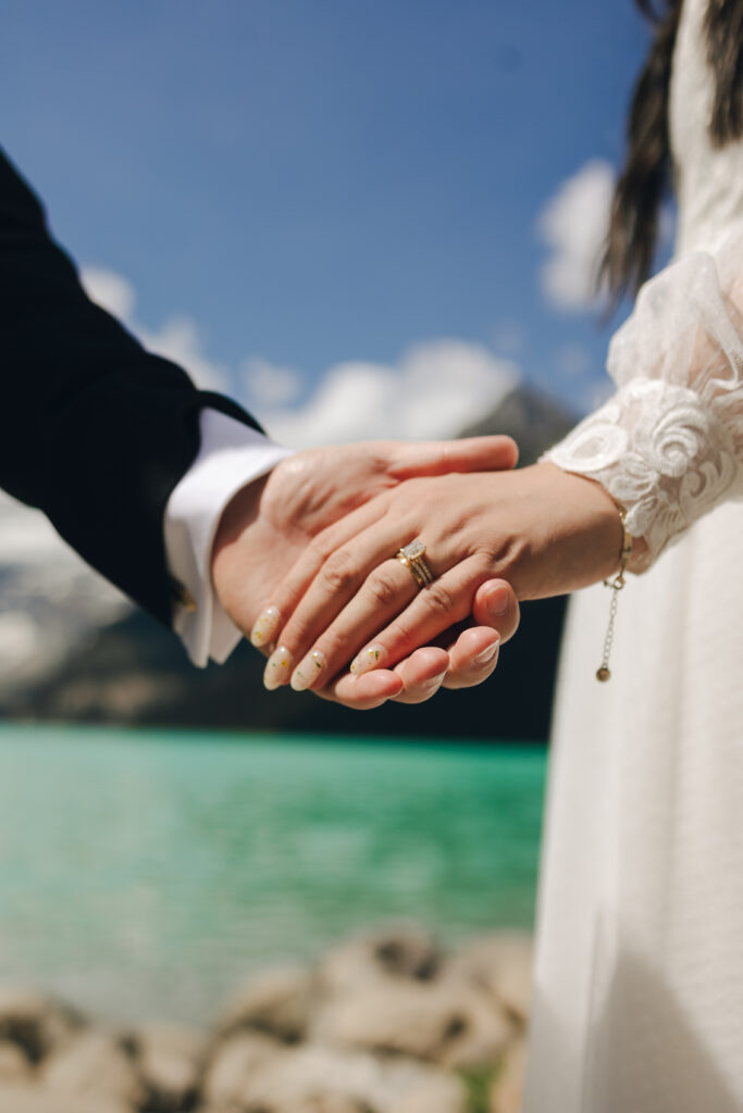bride and groom hold hands, show off the ring