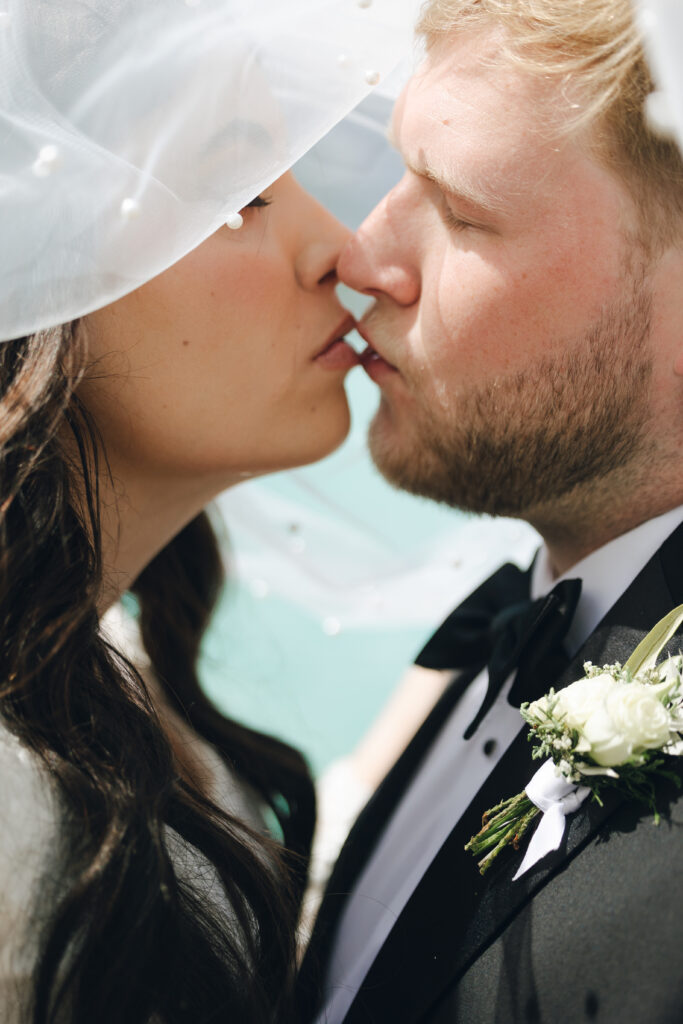 bride and groom kiss at lake louise