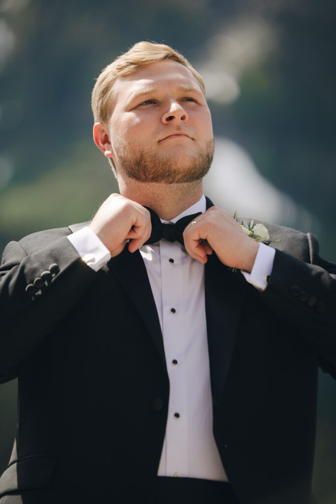 groom adjusts his bowtie