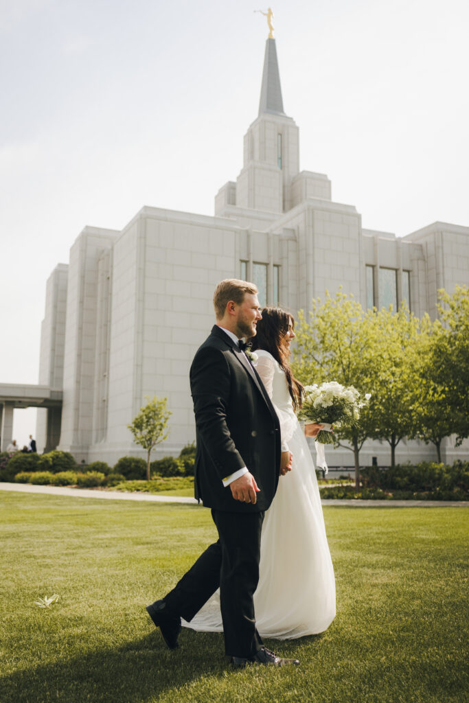 bride and groom walk on the grass after wedding ceremony