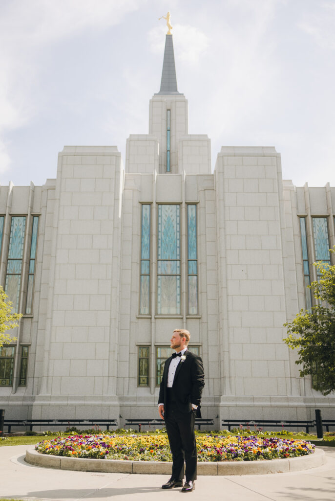 groom standing in front of the temple after wedding ceremony