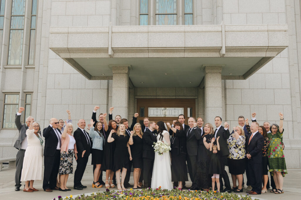 bride and groom cheering with family after the wedding ceremony