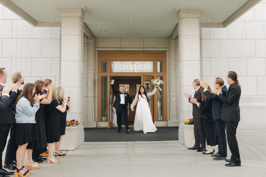 bride and groom exit the temple from their LDS wedding ceremony