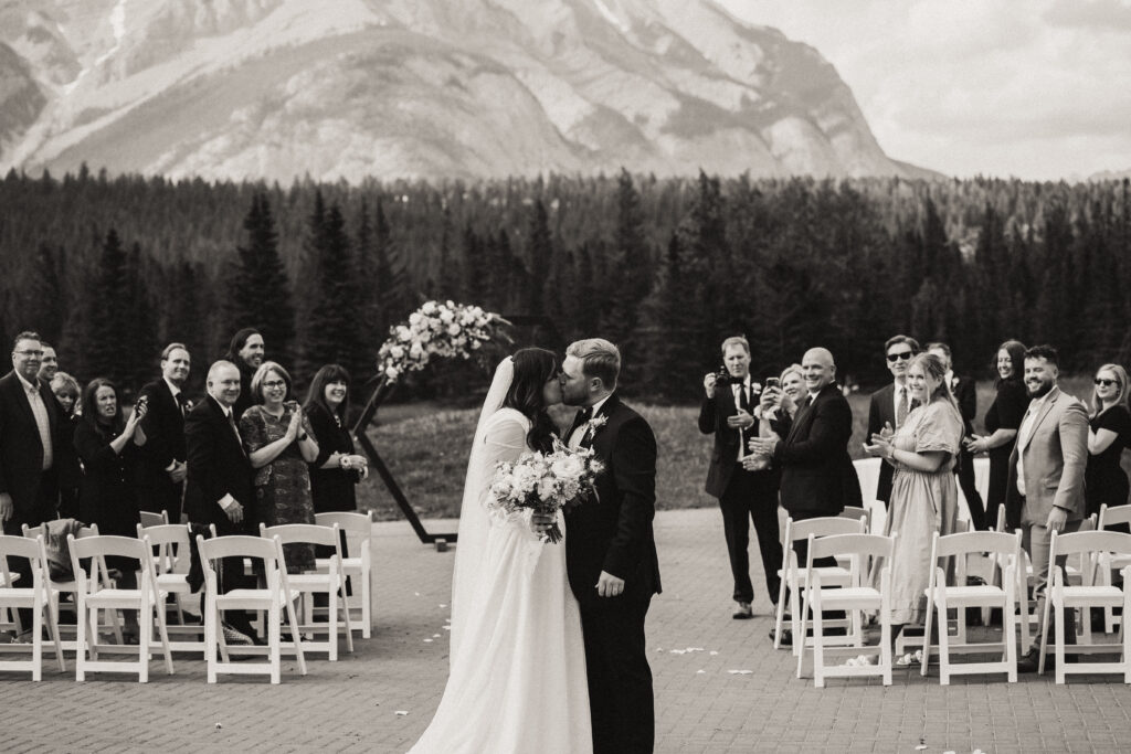 bride and groom kiss as they walk back down the aisle as husband and wife