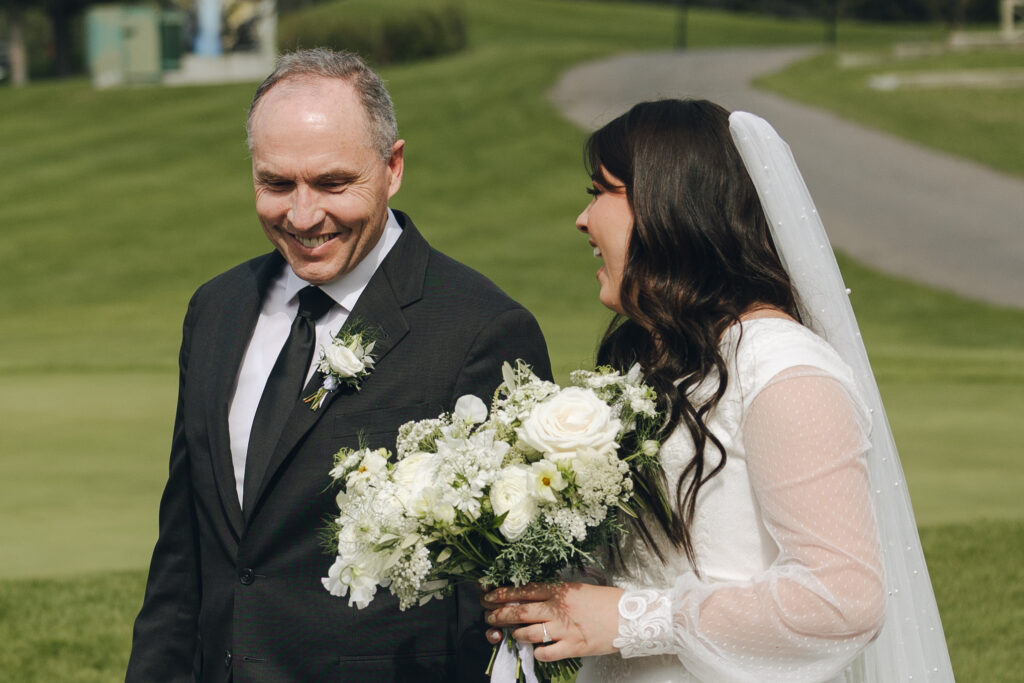 father and daughter share a sweet moment walking down the aisle