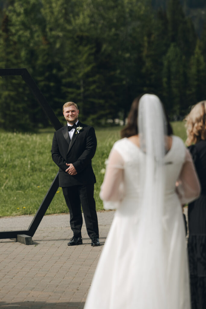 groom sees his bride walking down the aisle toward him
